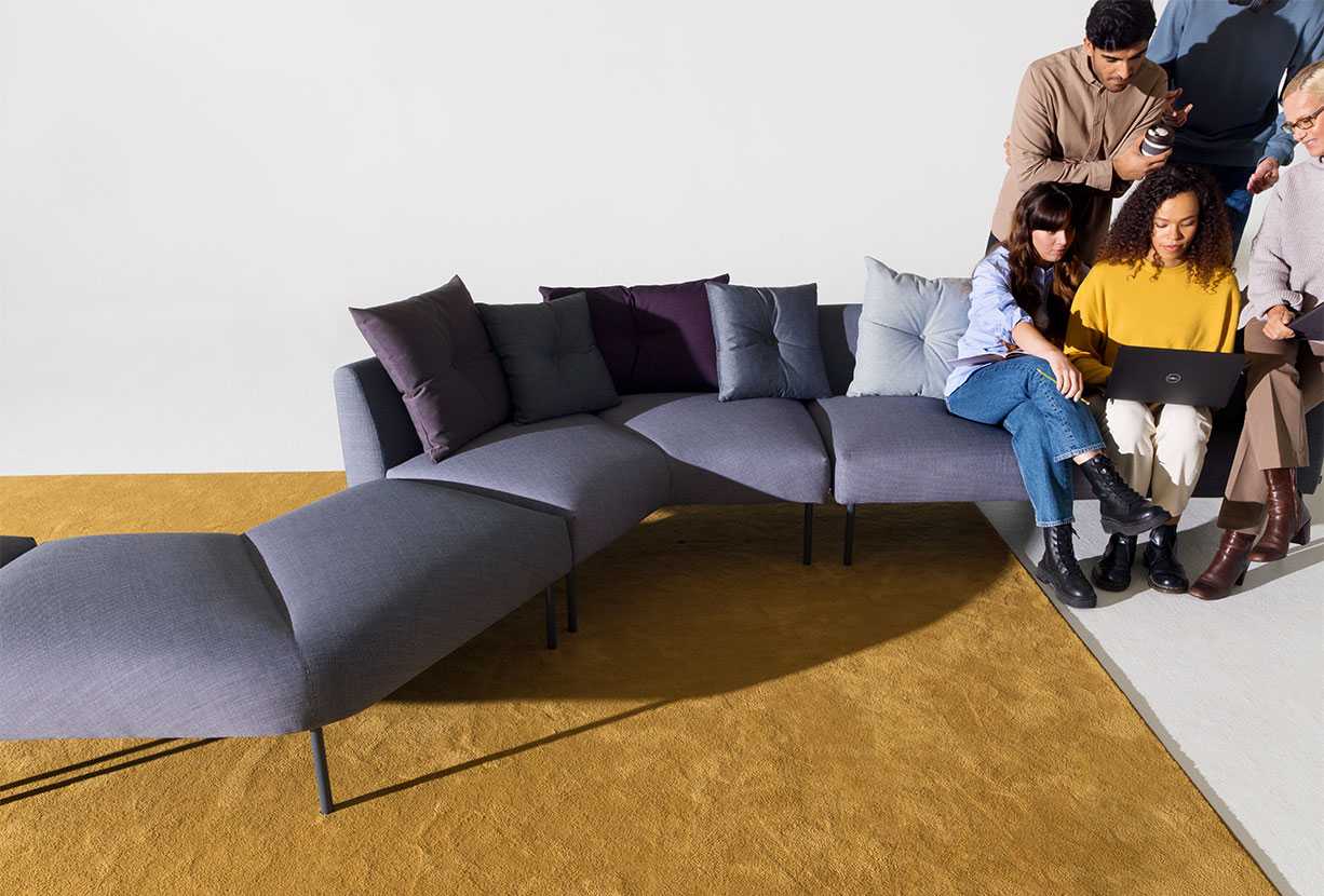 People sitting close to each other on a sofa while the other end is empty