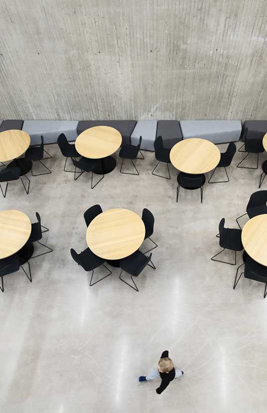 A pupil walking past table groups