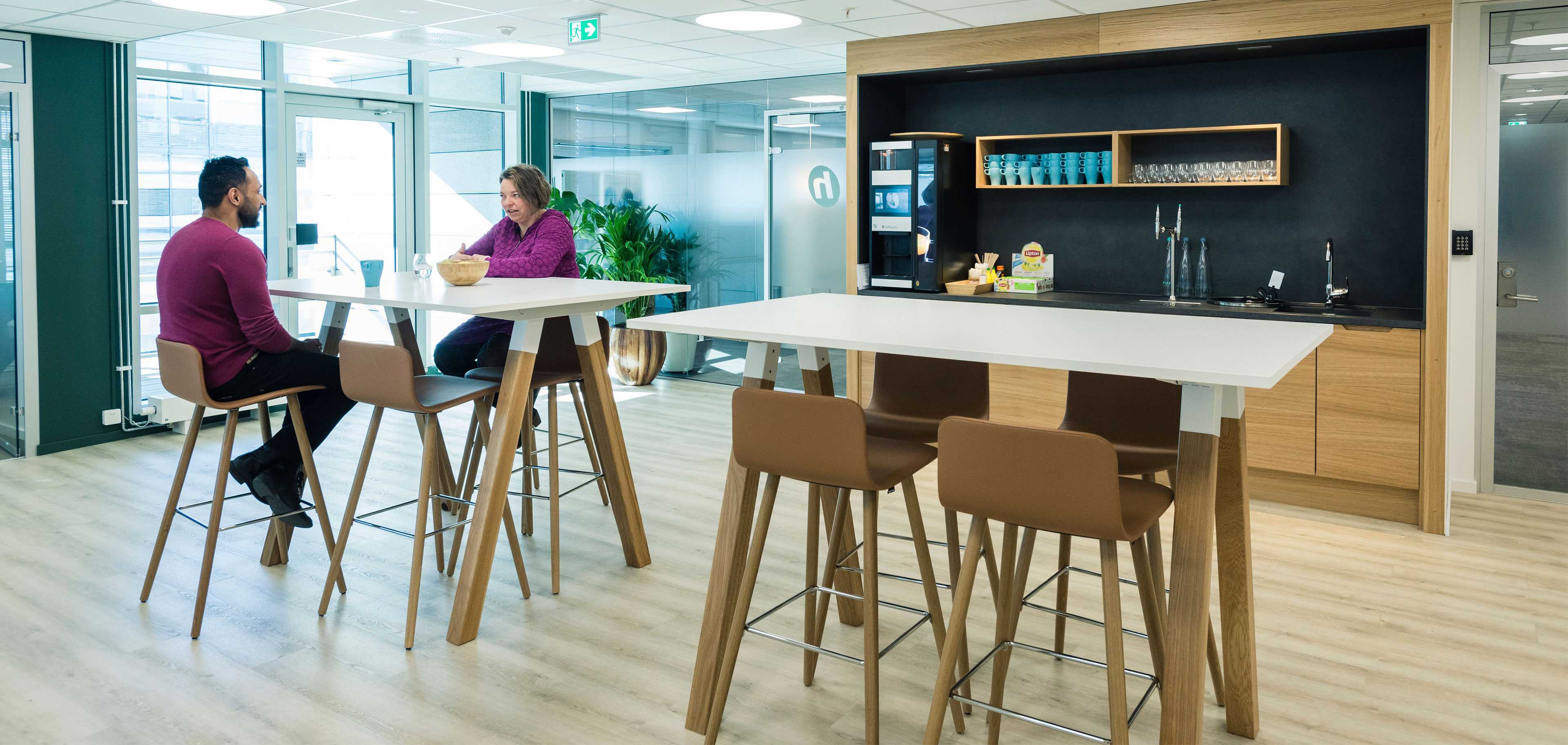 People sitting at Martela's Sola chairs and Frankie table in Holte Consulting's office