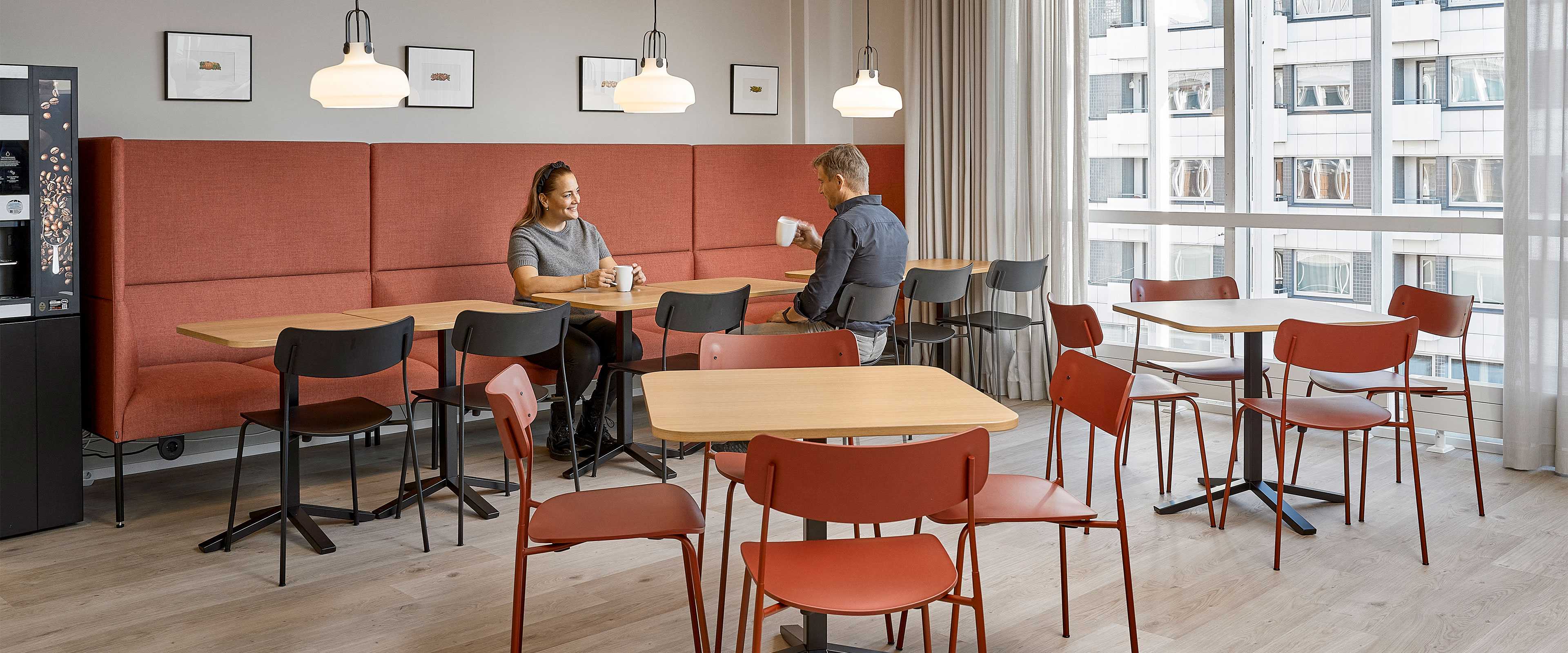 Kaksi henkilöä kahvilla Orkla Suomen working cafe -tilassa