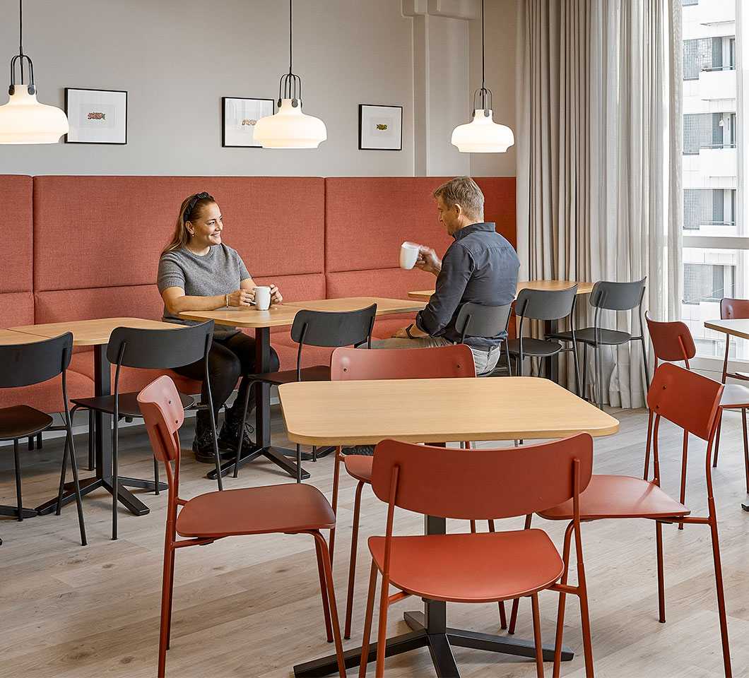 Kaksi henkilöä kahvilla Orkla Suomen working cafe -tilassa